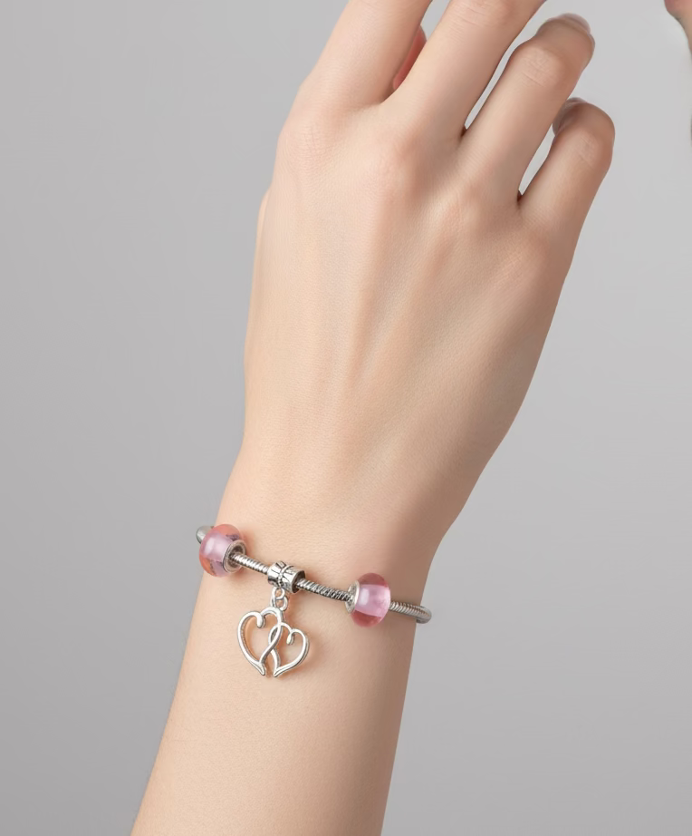 zilverkleurige bedelarmband met hartjes bedel en blaadjes bedel roze kralen
