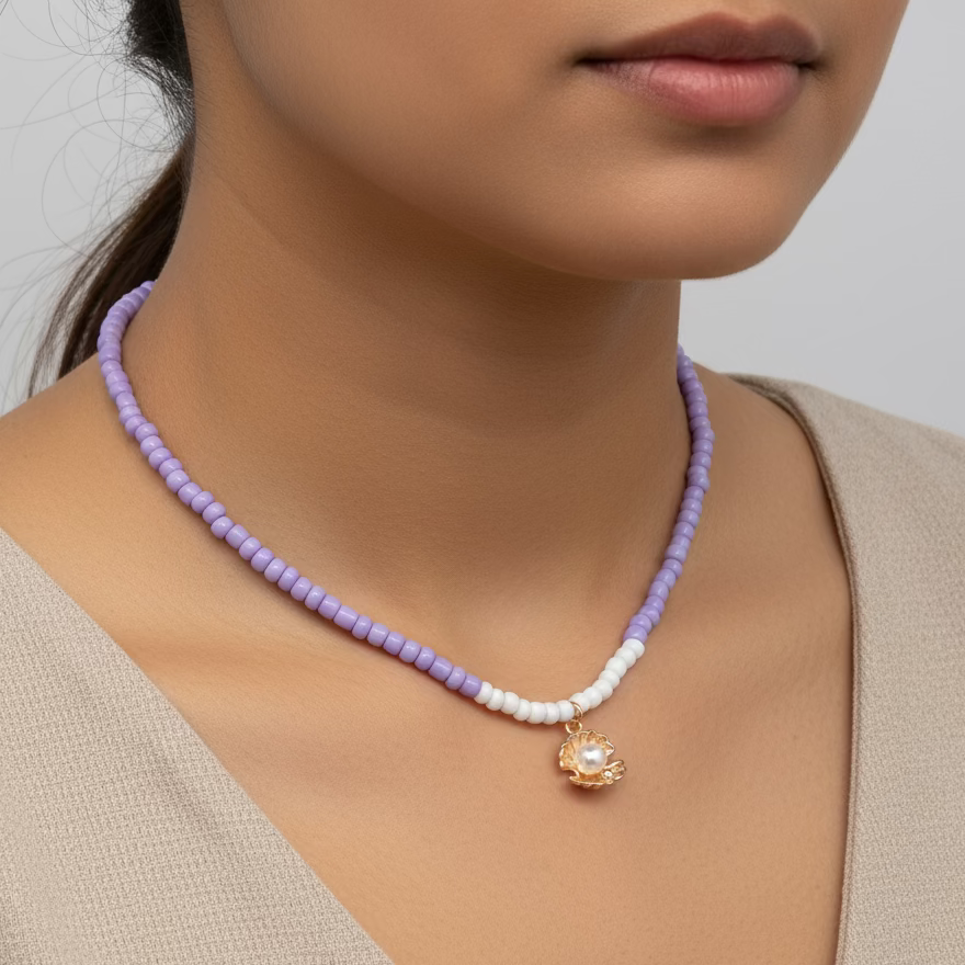 paarse kralen ketting met goudkleurige schelp met een pareltje