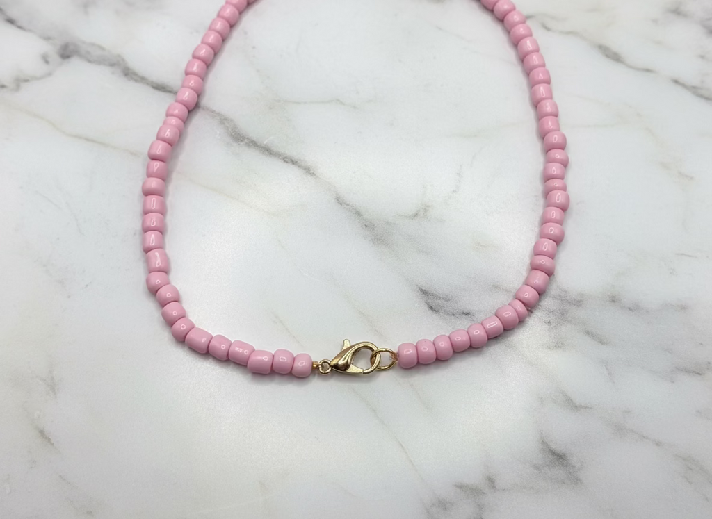 goudkleurige sluiting van licht roze ketting 