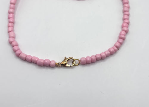 goudkleurige sluiting van licht roze ketting 