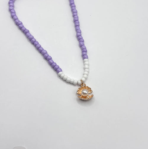 paarse kralen ketting met goudkleurige schelp met een pareltje 