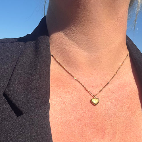 goudkleurige ketting met hartvormige hanger met de tekst LOVE 