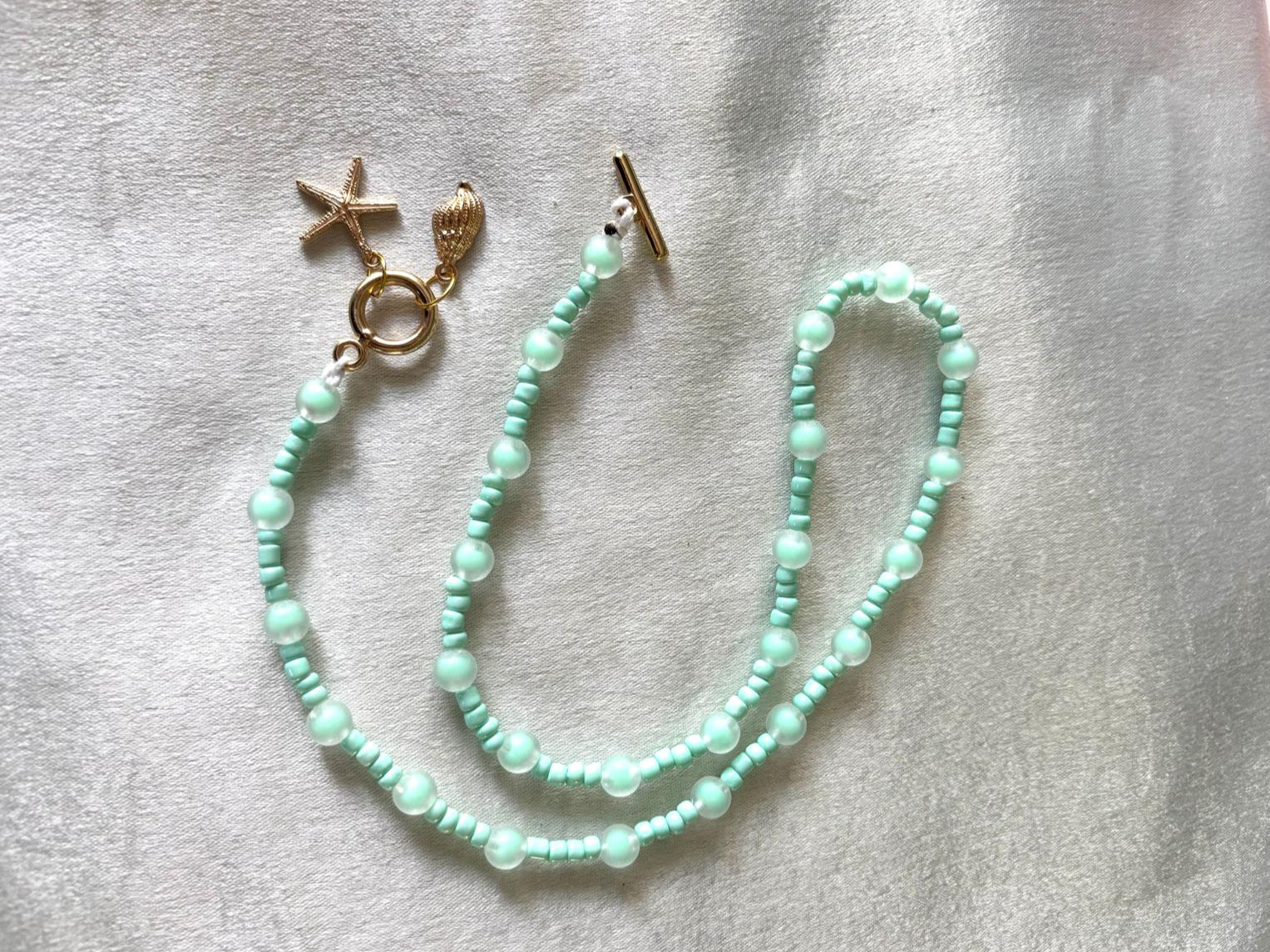 ketting licht groen met bedeltjes goudkleur oogsluiting 