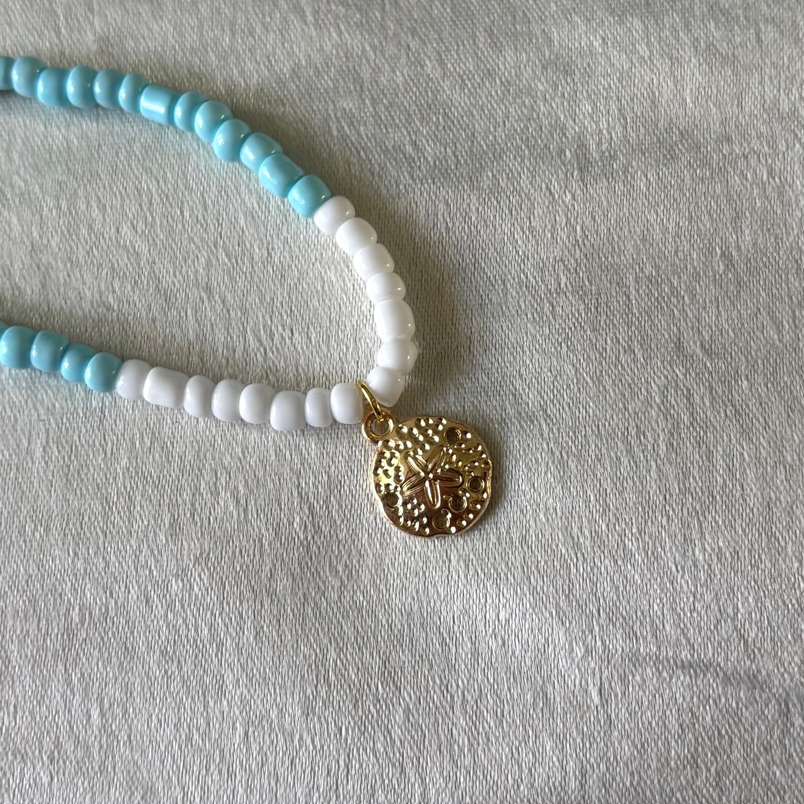 licht blauwe ketting met bedeltje goudkleurig 